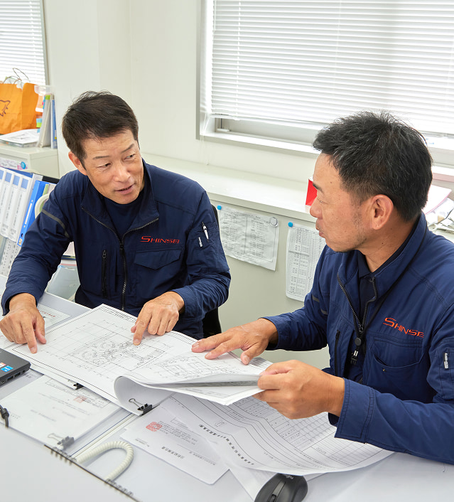 真生工業の職人らが解体工事現場の現地調査について話し合う様子